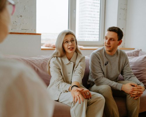 pexels-photo-3958379-3958379 A couple and therapist engaged in a discussion during a therapy session indoors.